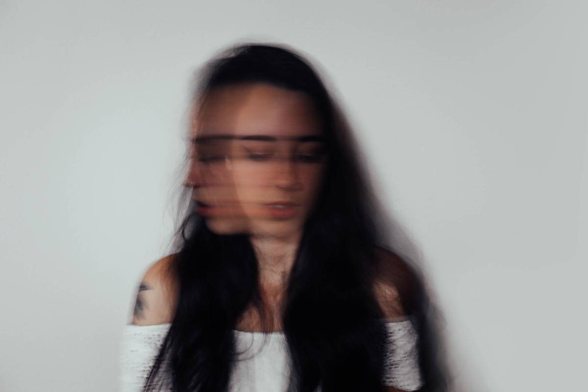 A long exposure of a woman shaking her head side-to-side.