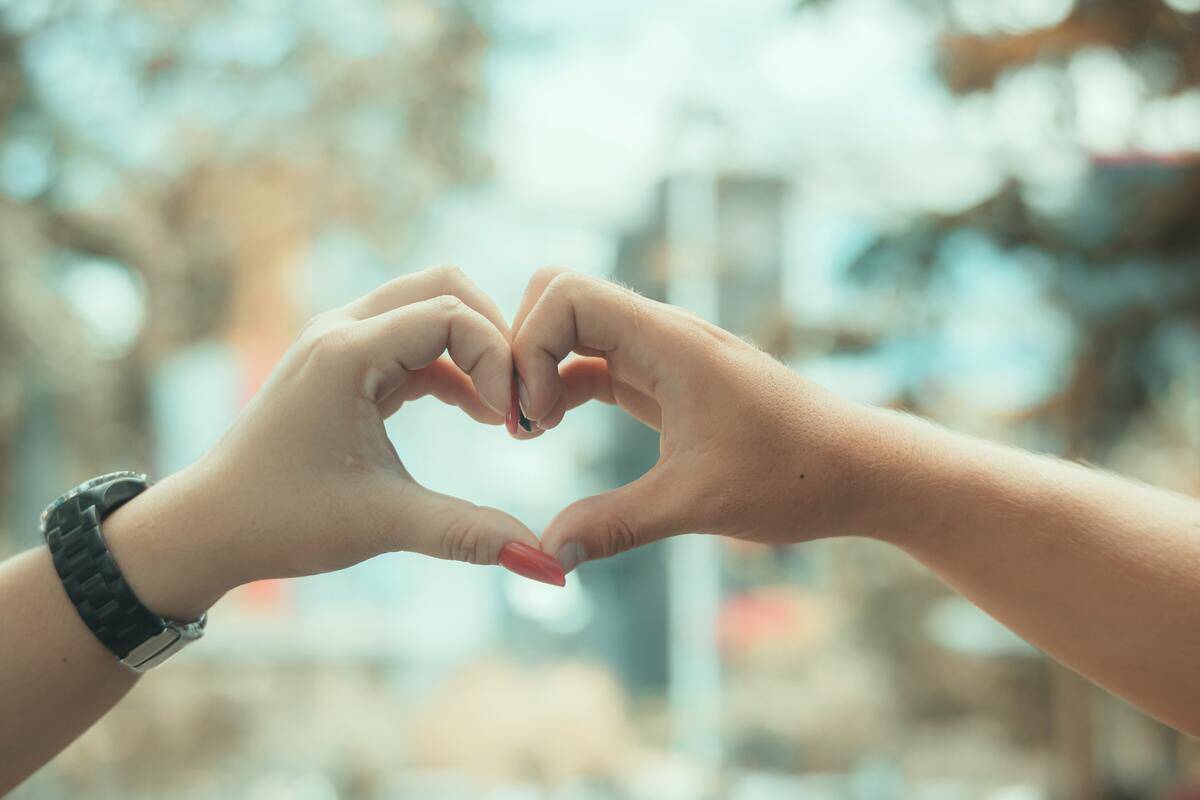 Two people making a heart shape with their hands.