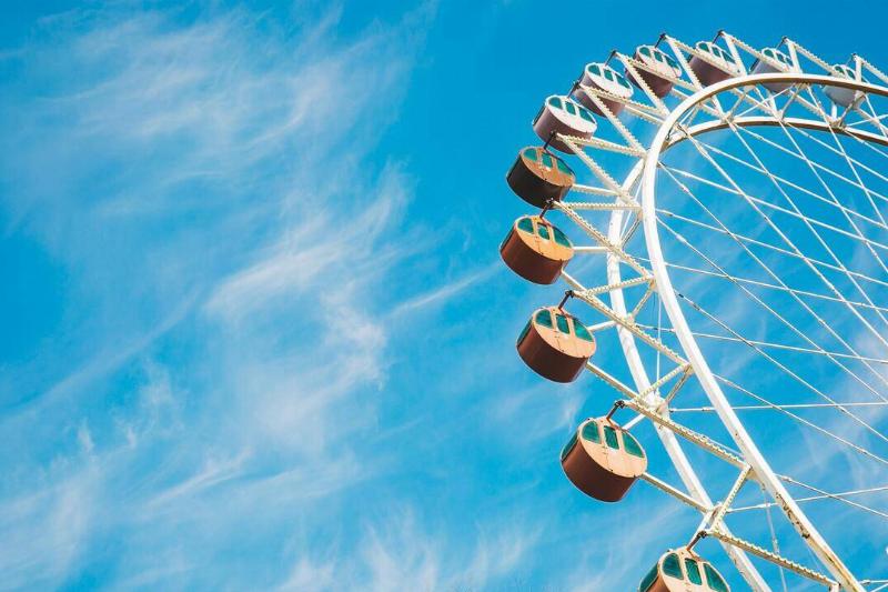 A ferris wheel shot from below against a bright blue sky. 