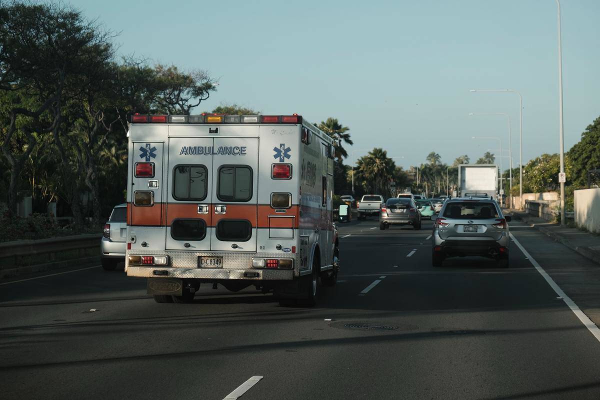 An ambulance driving down a road.