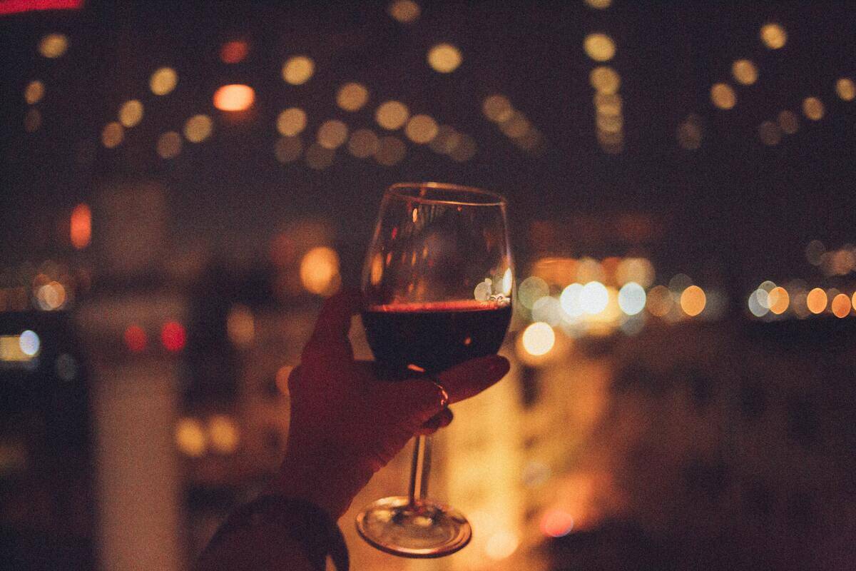 Someone holding up a glass of wine.