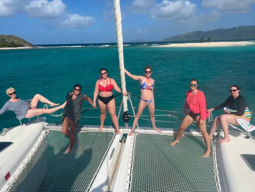 The four women (along with two others) in bathing suits on a boat.