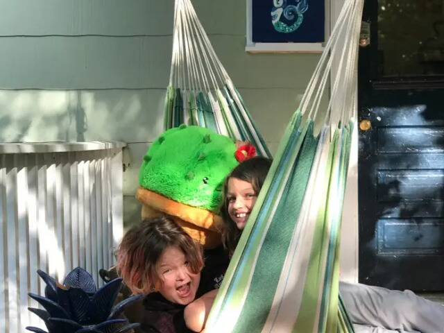 Two kids hanging out in a hammock.