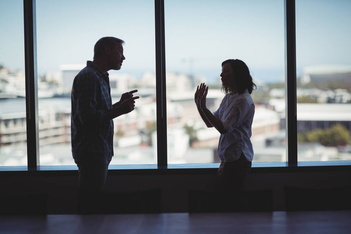 Couple arguing near the window in office