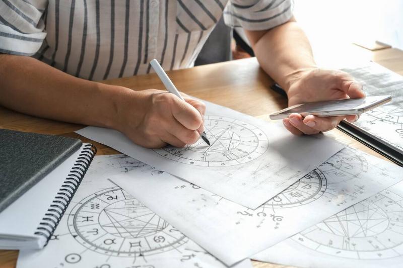 An astrologer calculating and drawing someone's birth chart.