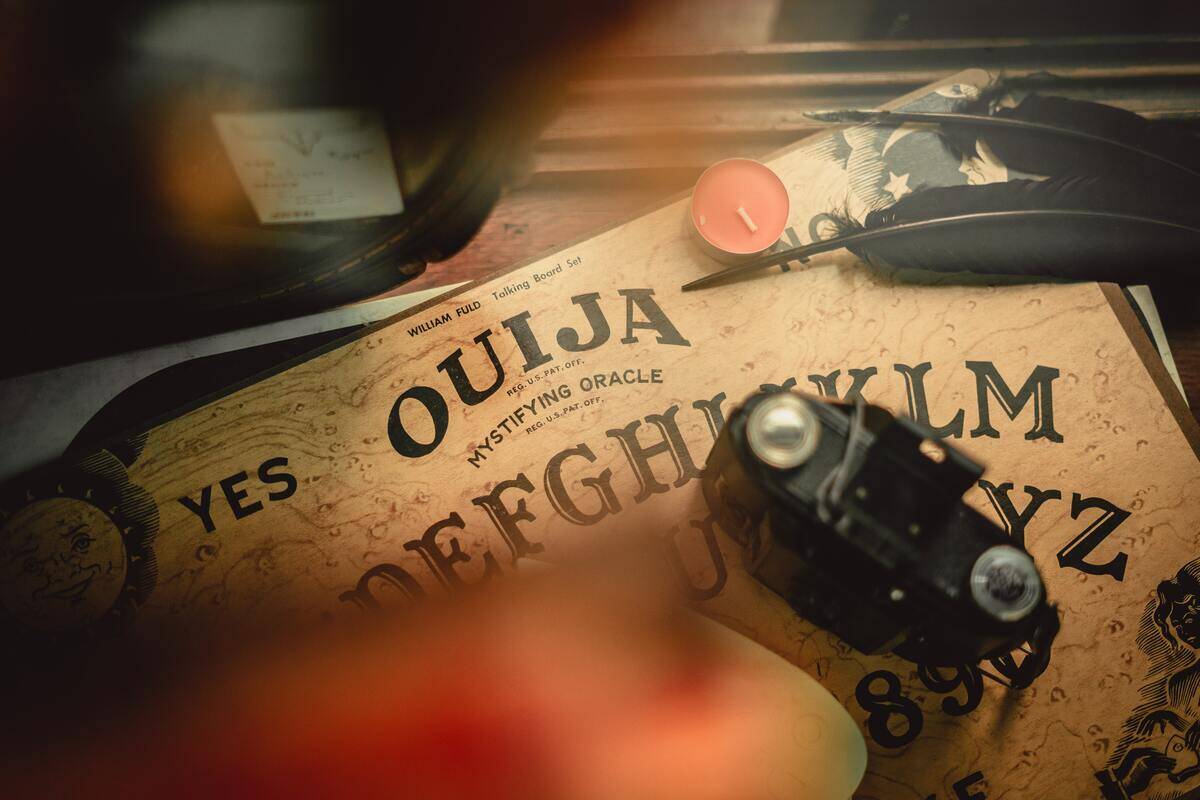 A Ouija board with a a number of items placed on top of it.