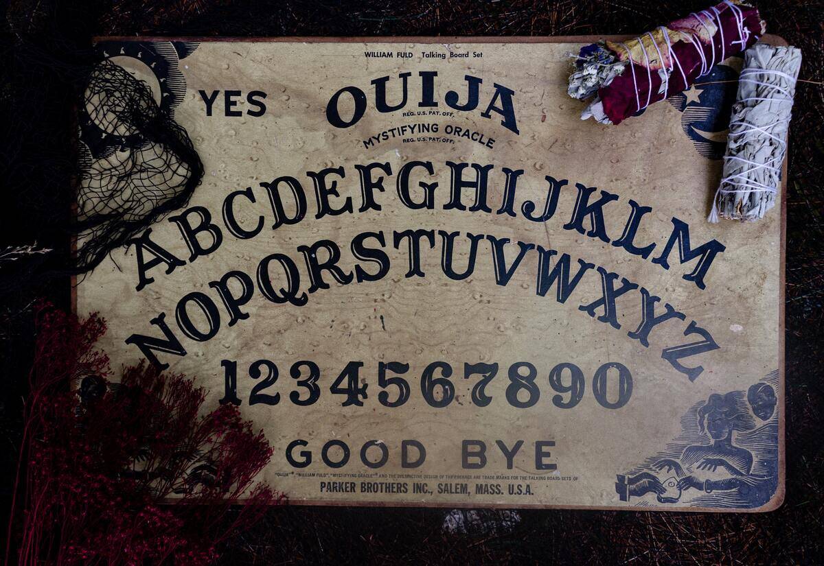 A Ouija board with some dried flowers around it.