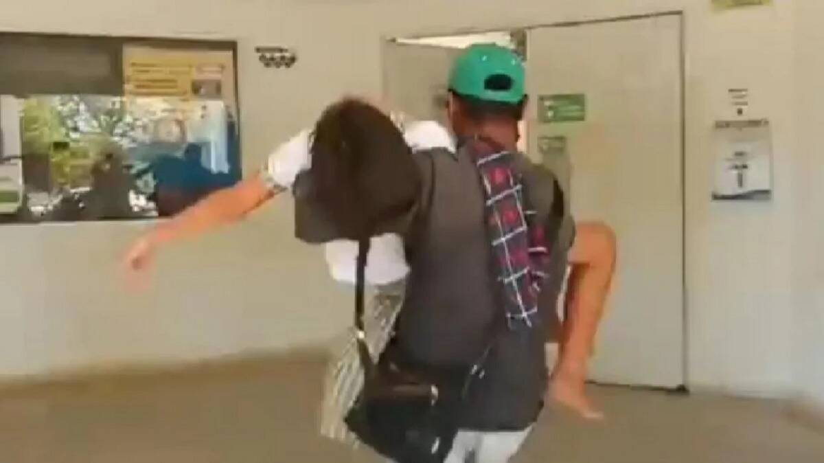 A man carrying fainted girl in his arms into the hospital.