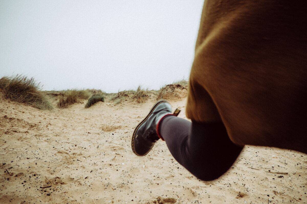 A shot of a woman's legs running away along a beach.