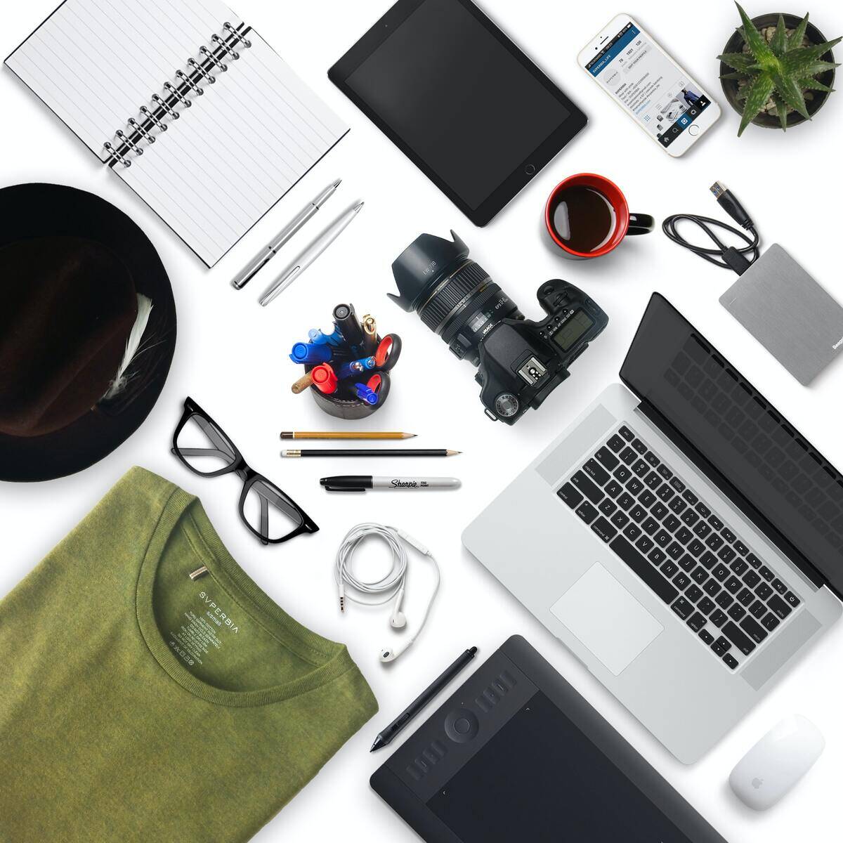 A table covered in geometrically organized office/photography supplies.