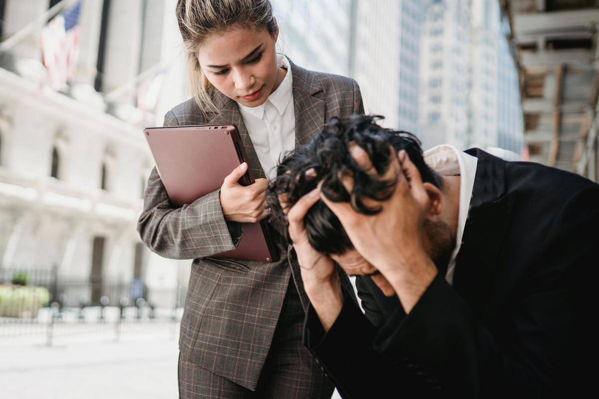 A business woman comforting a male colleague.