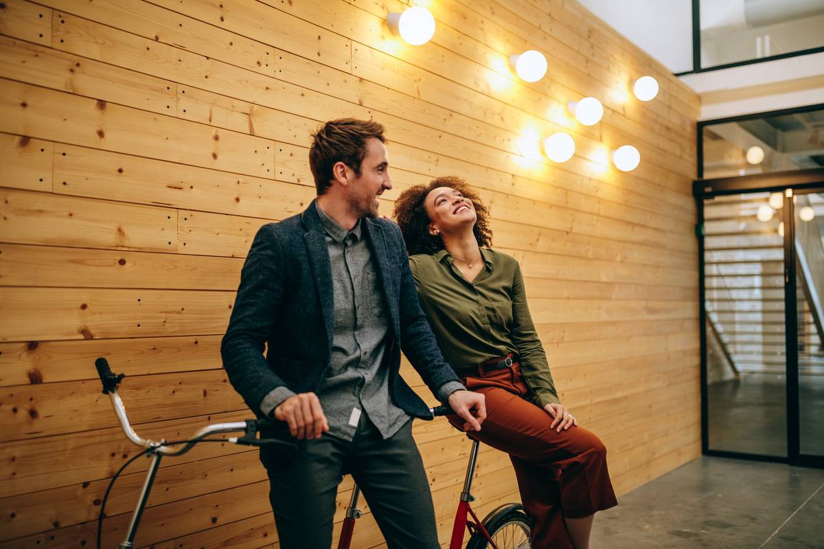 Cropped shot of two young businesspersons standing by a bicycle at their workplace.