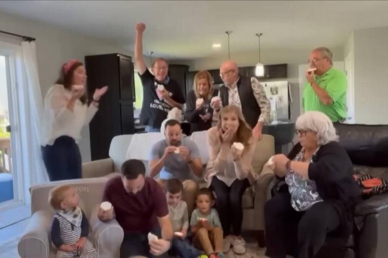 The family at the gender reveal party cheering after biting into the cookies.