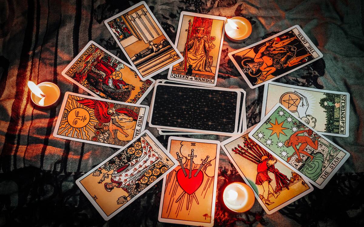 A stack of tarot cards on a table, singular cards in a circle around it.