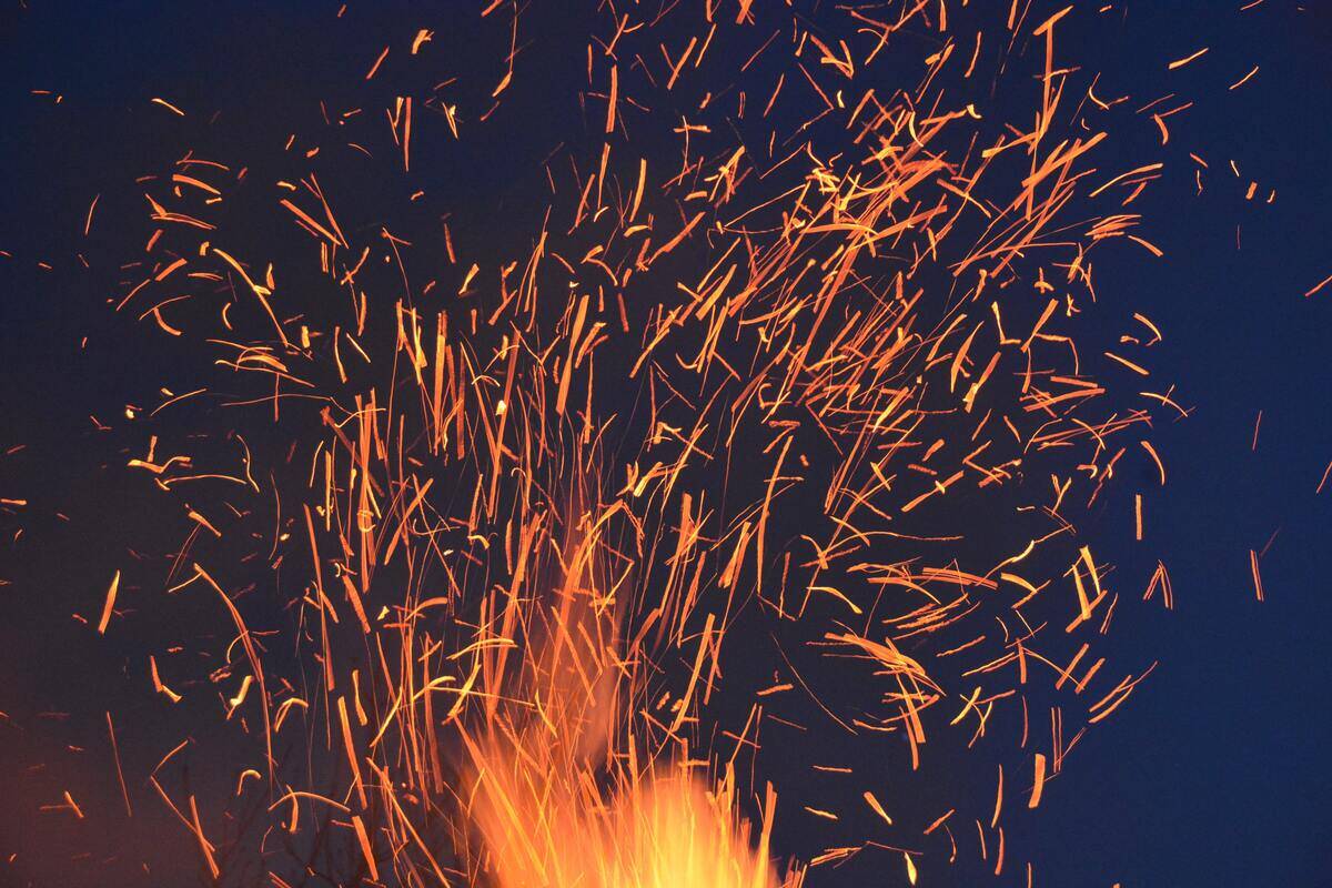 Sparks flying up from a campfire.