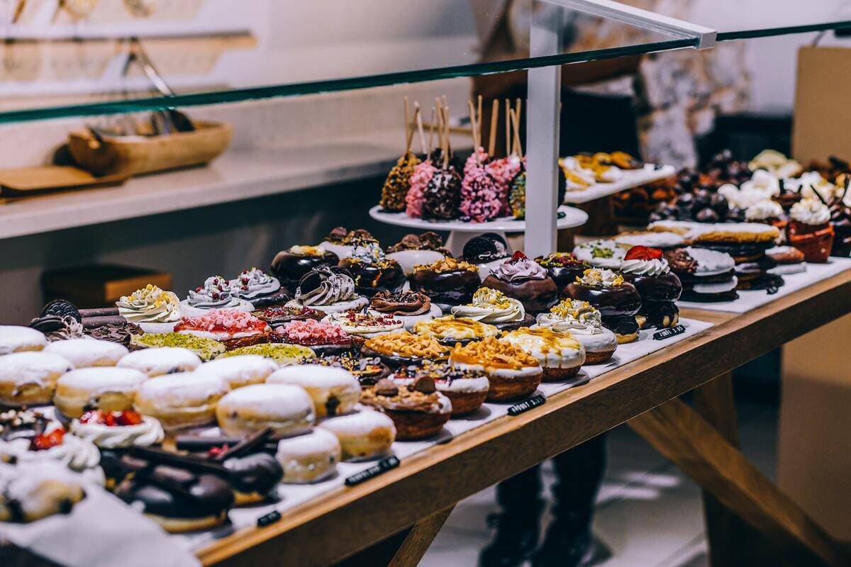 A display counter filled with a variety of desserts, mainly donuts.