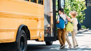 Young boys entering a school bus.