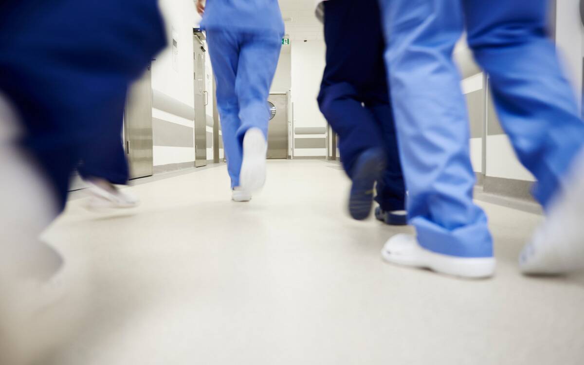 Doctors and nurses rushing down a hallway.