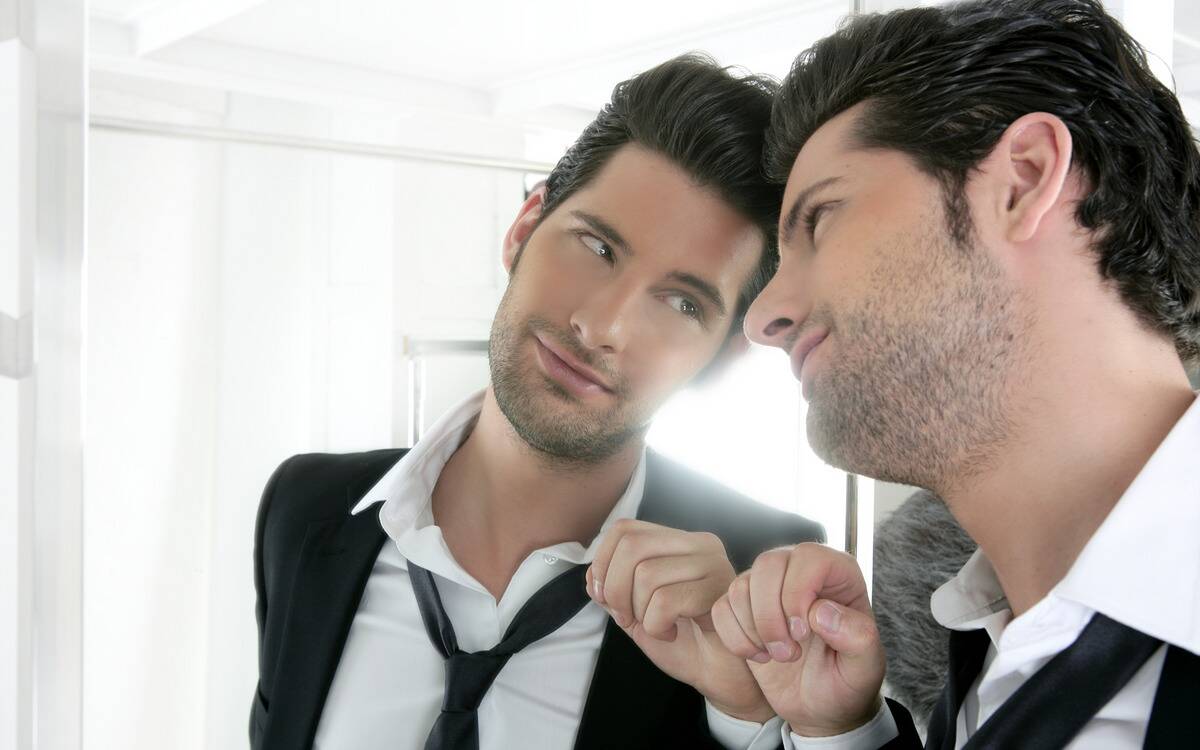 A man admiring himself in the mirror.