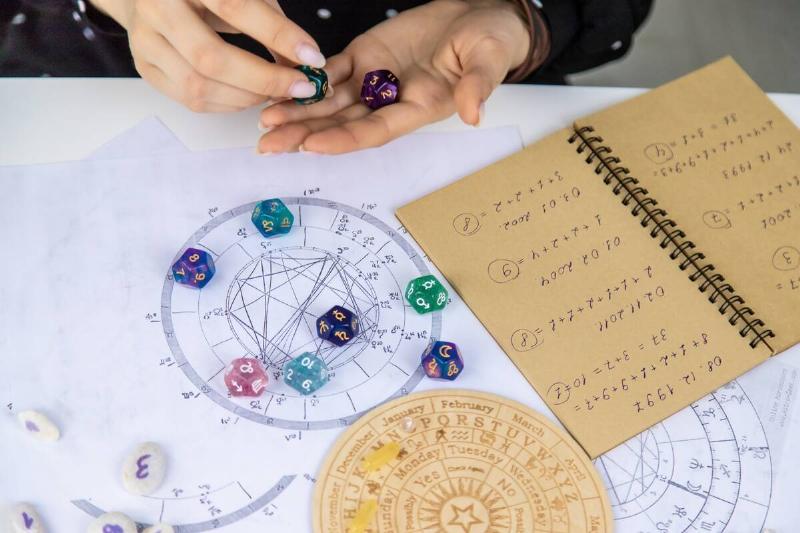 female numerologist astrologer counting numbers while looking at birth chart