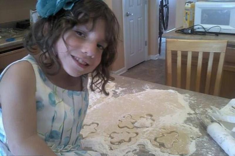 Natalia seated on top of a countertop where the family had been making cookies.
