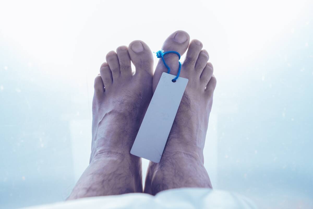 Feet of dead male person in morgue, close up of selective focus.