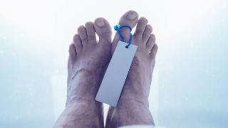 Feet of dead male person in morgue, close up of selective focus.