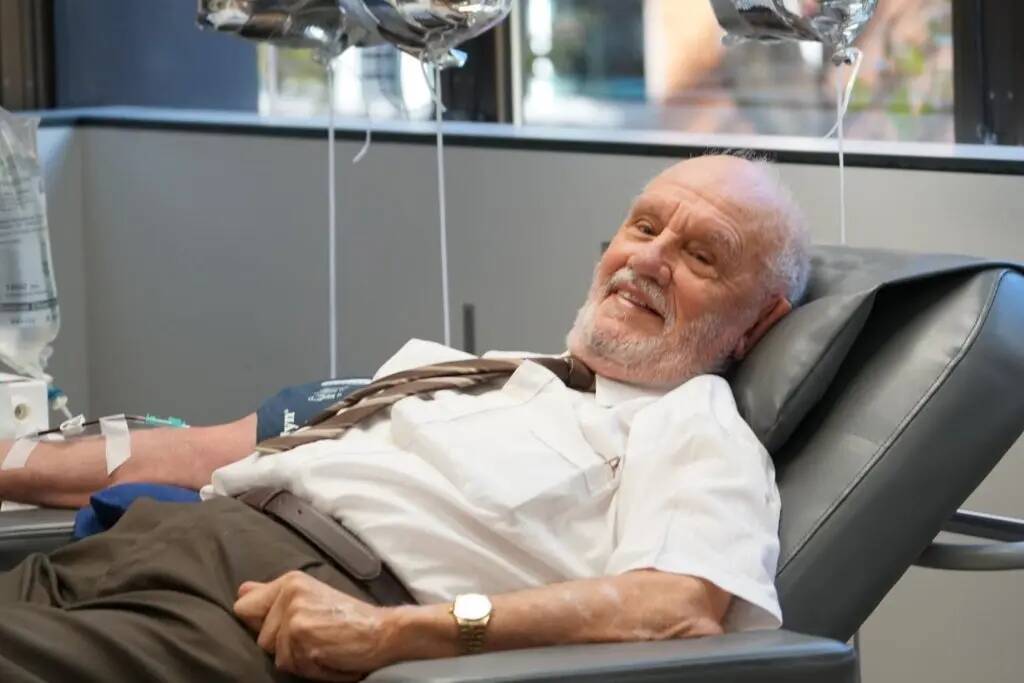 James smiling, laying back in his chair as he donates blood.