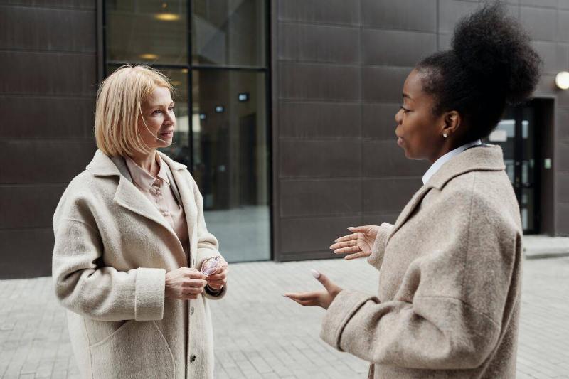 two women outside office building talking 