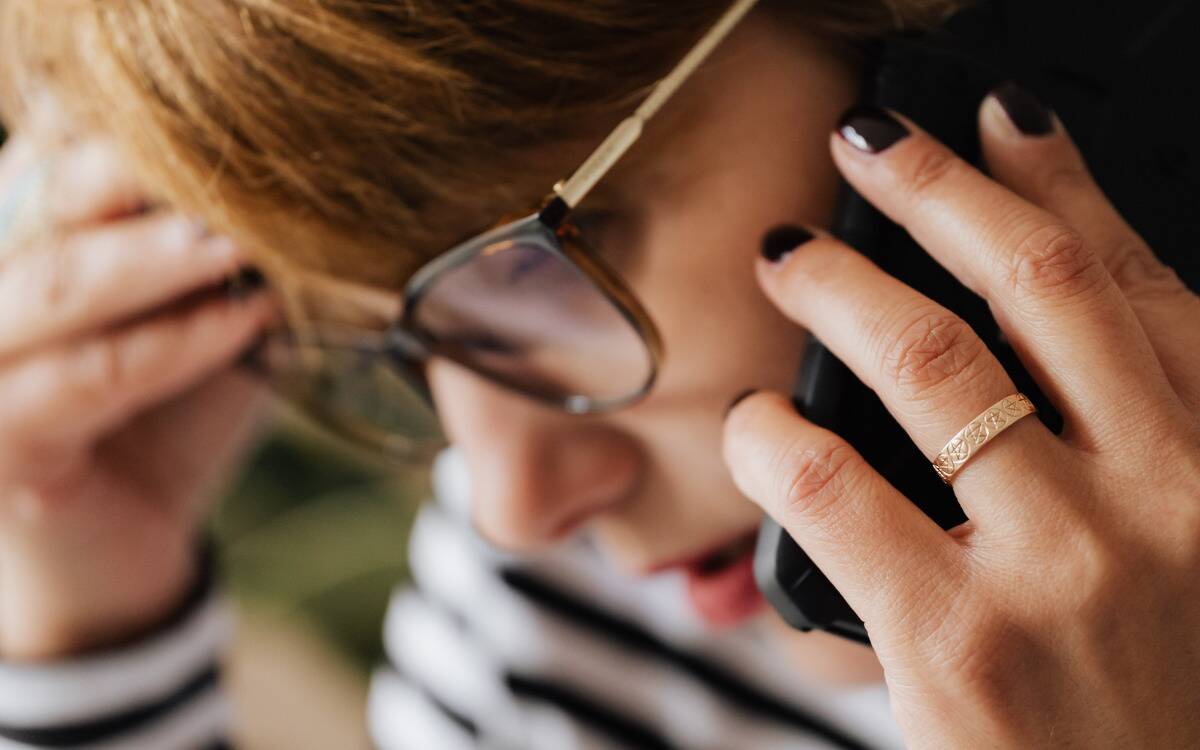 A woman appearing stressed while talking on the phone.