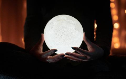 Someone holding a moon light in their hands.