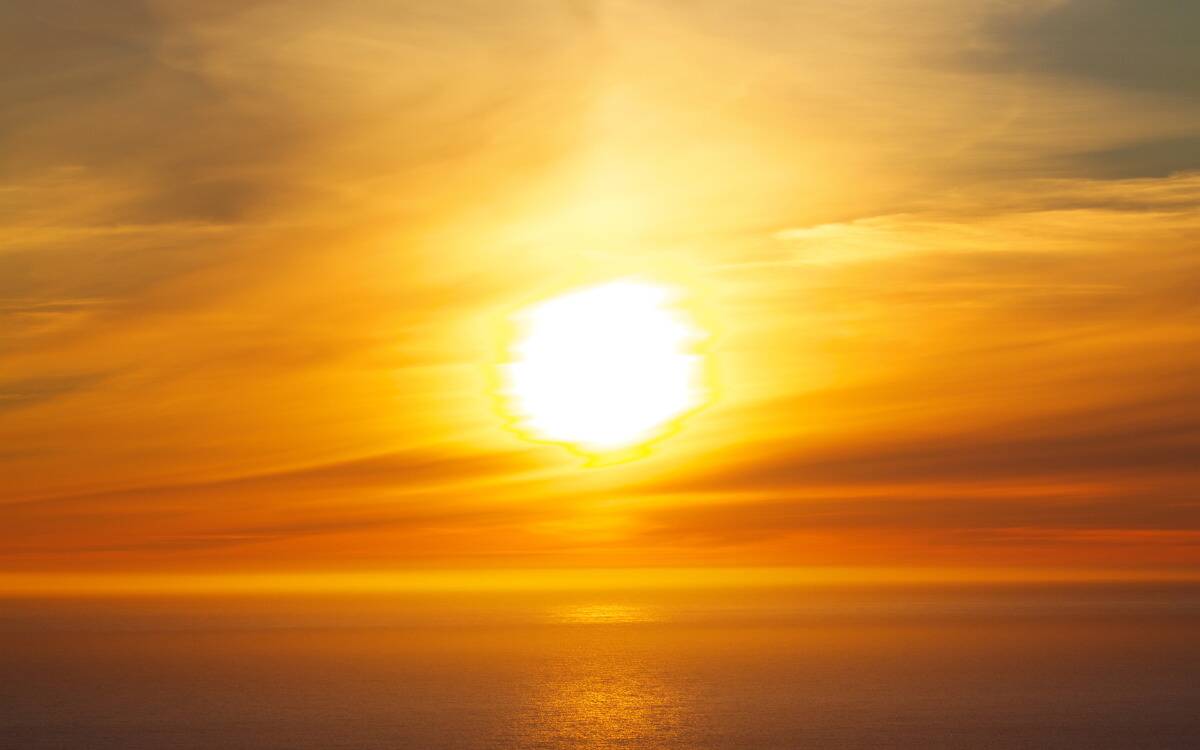 The sun in the sky during a sunset.