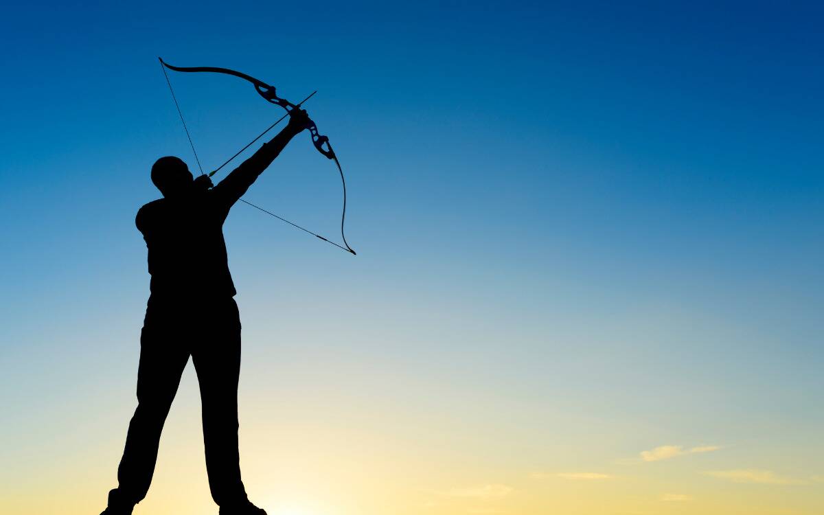 A silhouette of a man aiming a bow and arrow upwards.