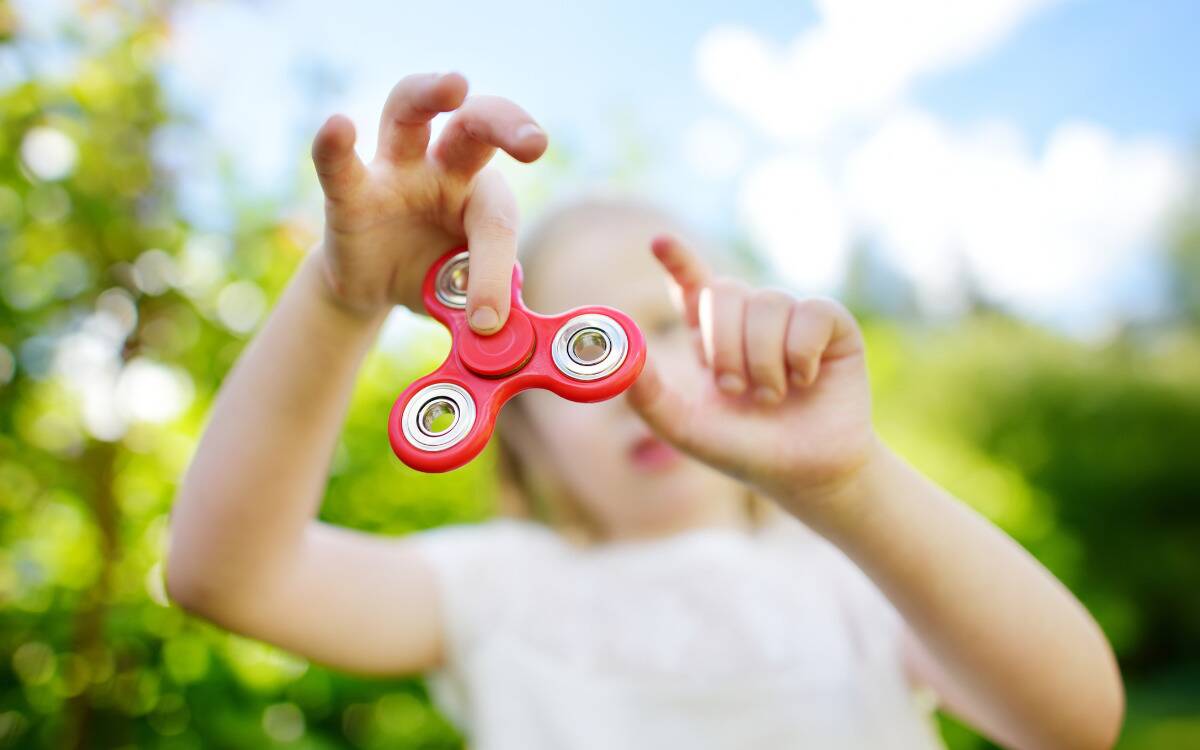 A kid playing with a fidget spinner.