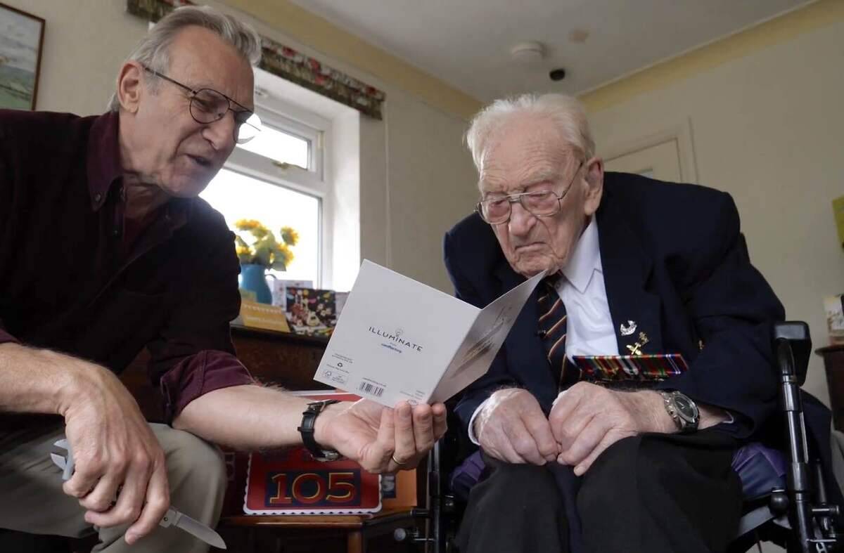 Ernest Horsfall reading one of his birthday cards alongside a friend of his.