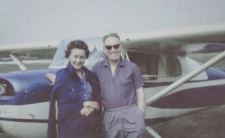 An old photo of Ernest Horsfall and his wife posing next to a passenger plane.