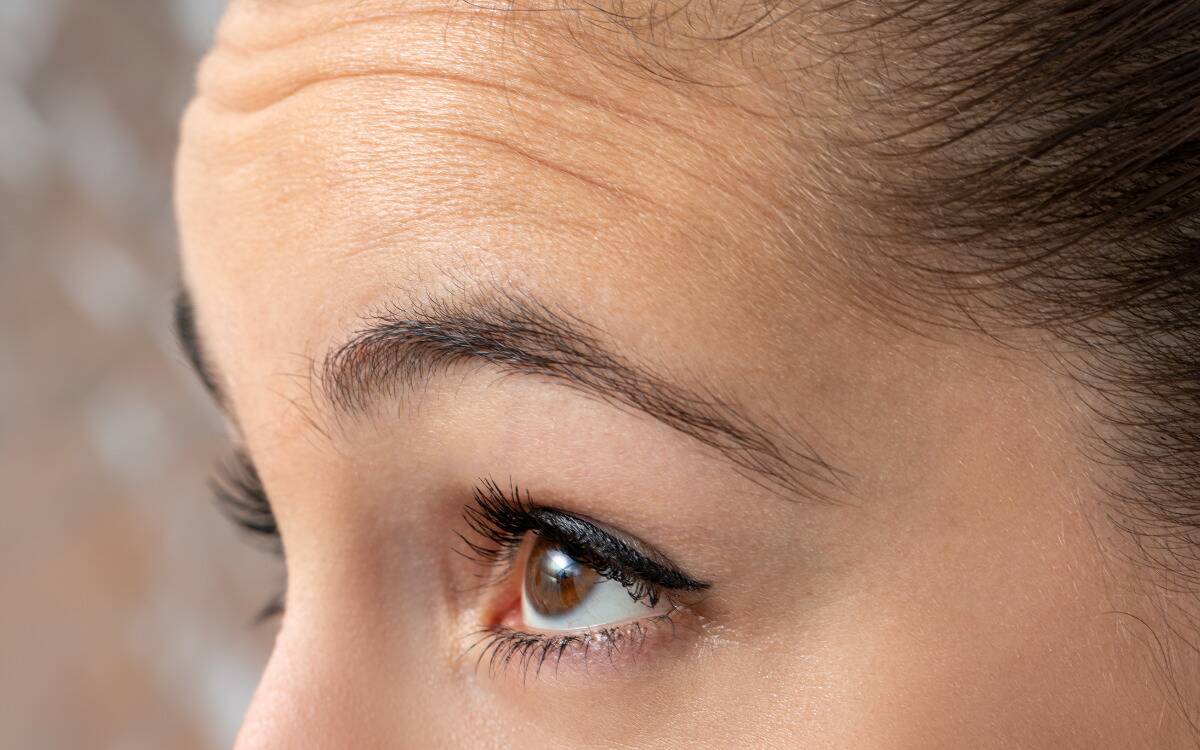 A closeup of a woman's eyes and forehead as seen from a 3/4 angle.