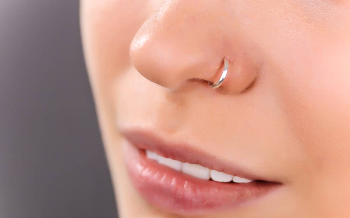 A closeup of someone's nose in which there's a ring in one nostril.