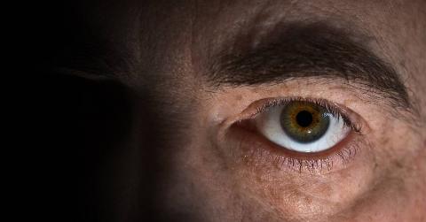 A darkly lit closeup on a man's eye.