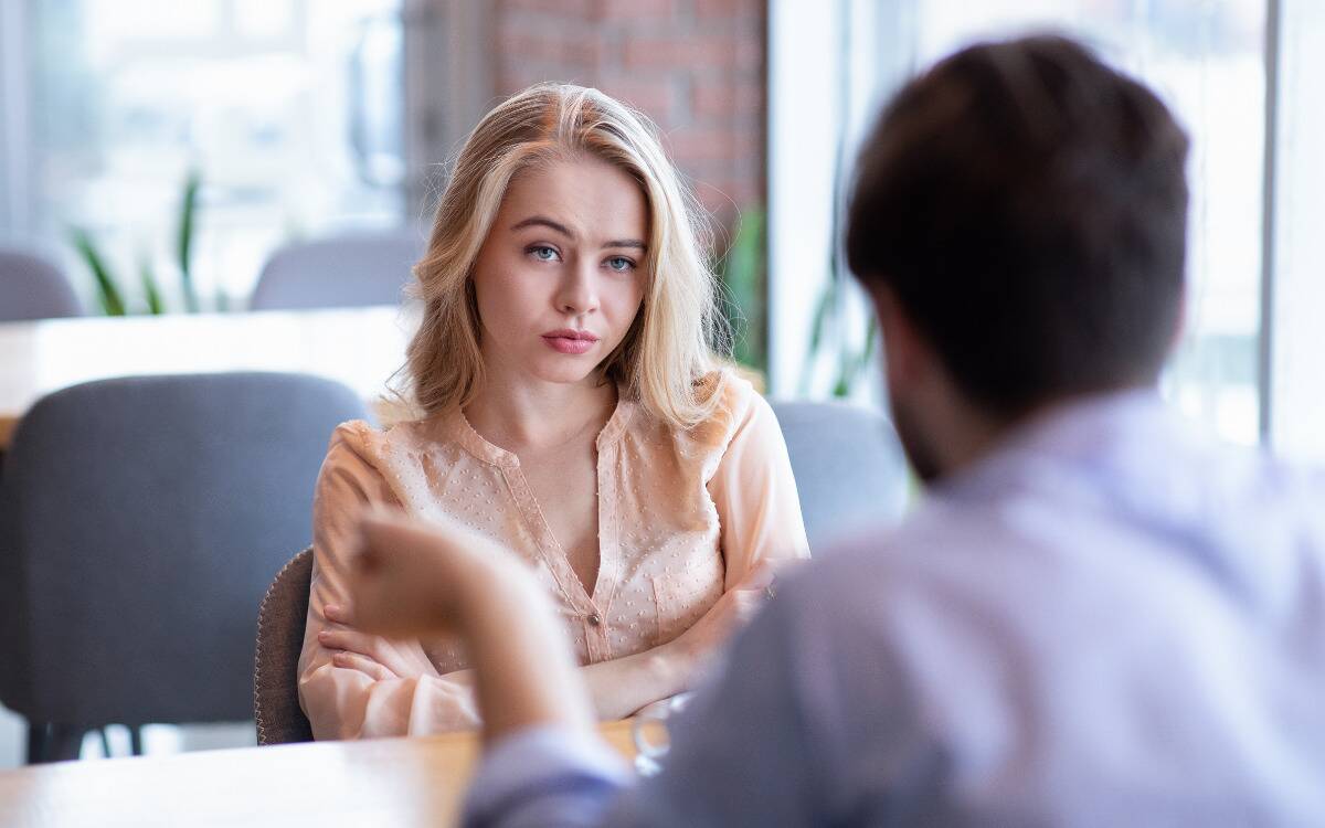 A woman looking annoyed and incredulous while a man is talking to her.