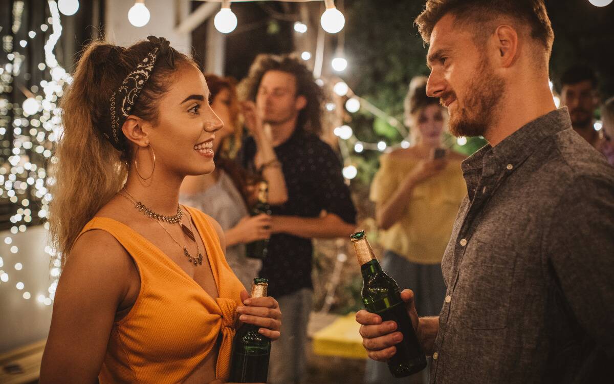 A man and woman chatting during a social gathering.