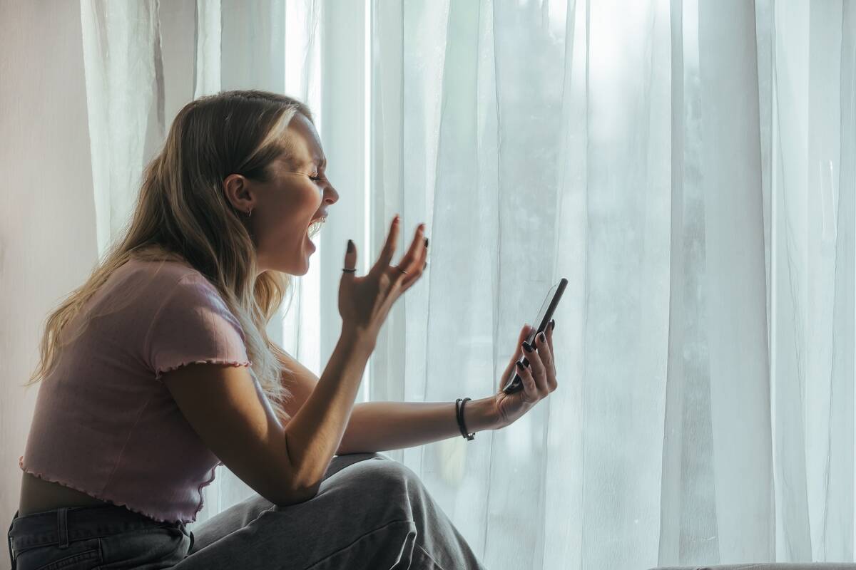 An angry woman yelling into her phone.