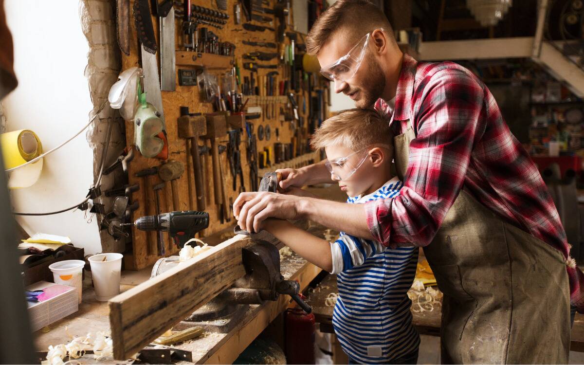 A father teaching his son how to woodwork.