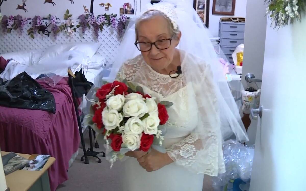 Fideli in her wedding dress on the day of the ceremony, holding her bouquet.