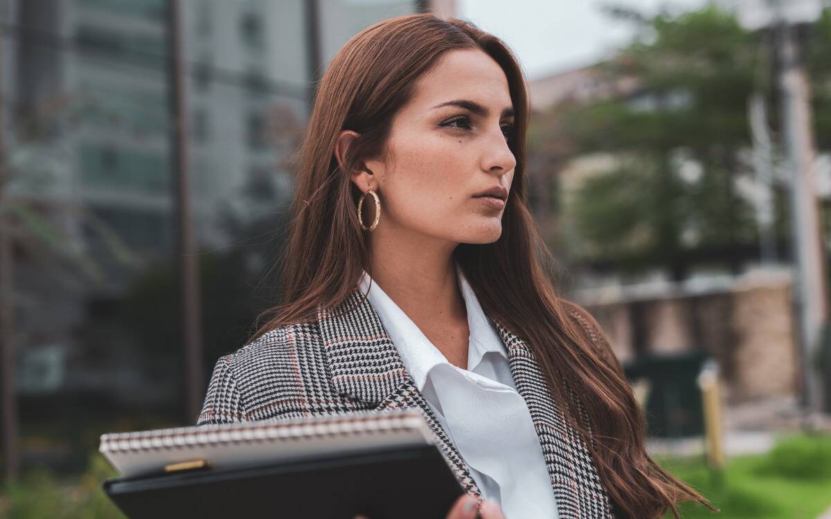 A business woman with a stern expression standing outside.