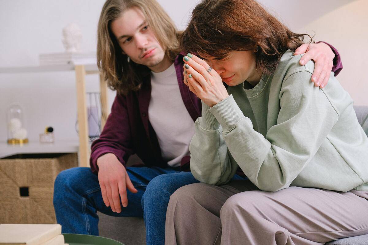 Someone comforting a friend as they cry.