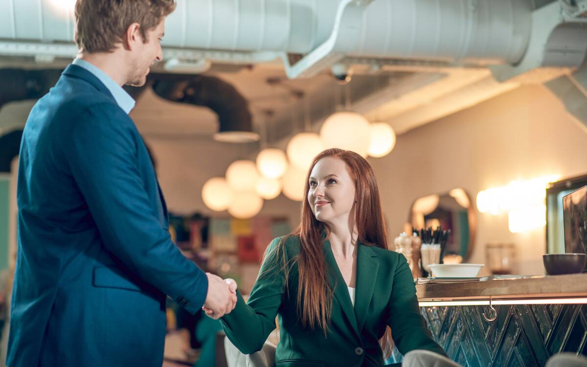 A woman shaking a man's hand upon first meeting.