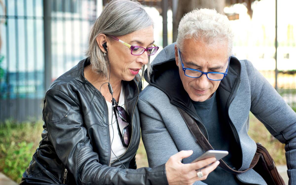 A woman showing a man something on her phone.