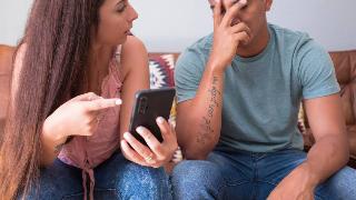 A woman confronting a man about what's on his phone.