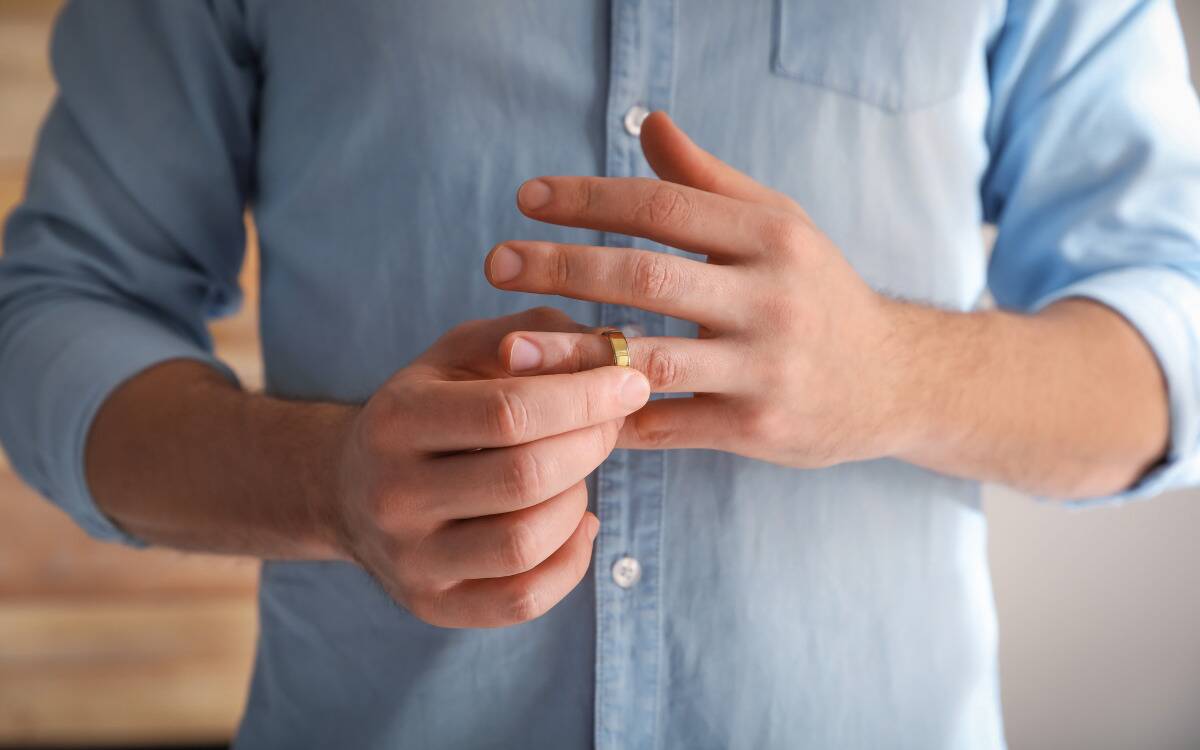 A man taking off his wedding ring.